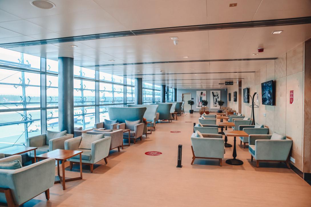 A spacious lounge with comfortable chairs and coffee tables in Business Lounge at Riga Airport